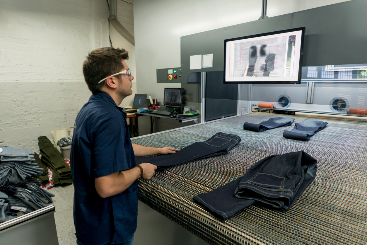 Man Operating A Laser Machine At A Clothing Factory