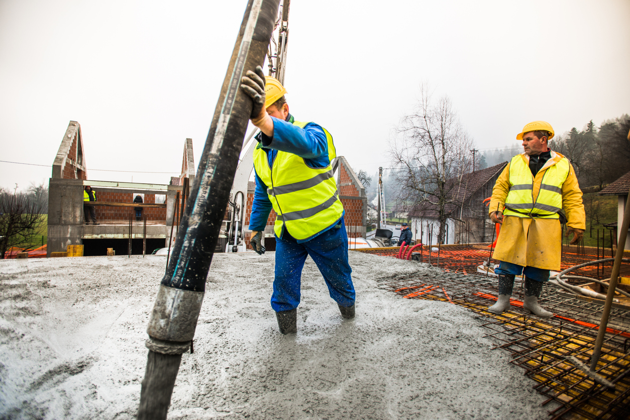 Construction Workers Pouring Cement On Roof