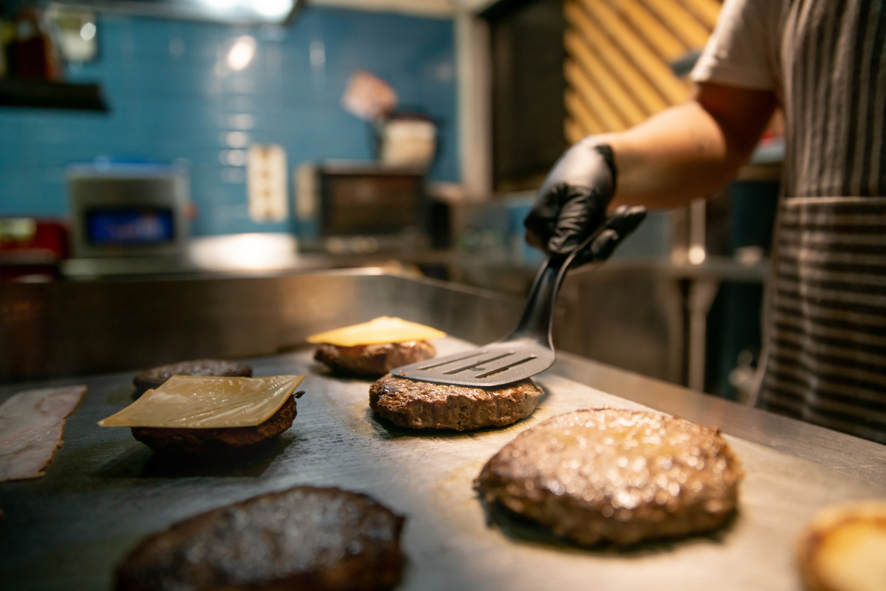 Close Up On A Chef Preparing Burgers At A Restaurant